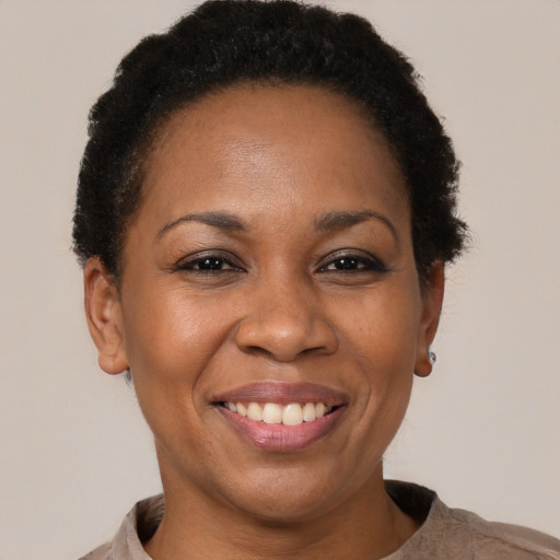 Joyful black adult female with short  brown hair and brown eyes