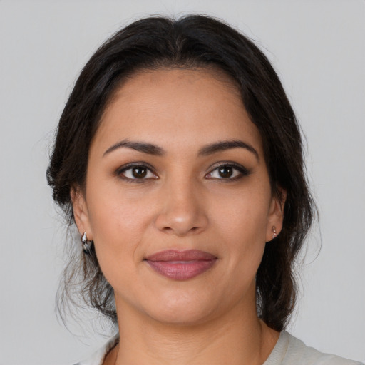 Joyful latino young-adult female with medium  brown hair and brown eyes