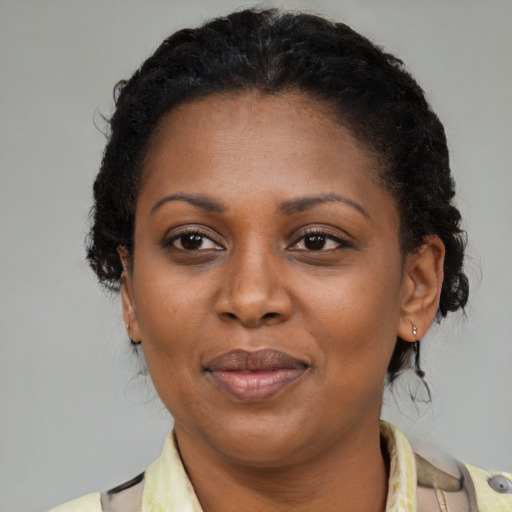 Joyful black adult female with medium  brown hair and brown eyes