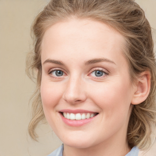 Joyful white young-adult female with medium  brown hair and blue eyes