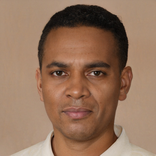 Joyful black young-adult male with short  black hair and brown eyes