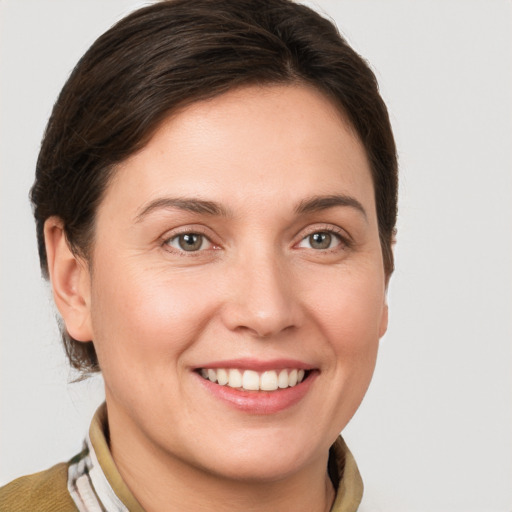 Joyful white young-adult female with short  brown hair and grey eyes