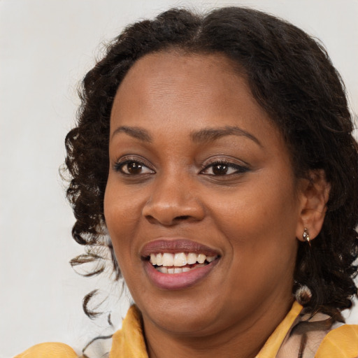 Joyful black young-adult female with medium  brown hair and brown eyes
