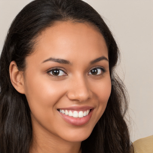 Joyful latino young-adult female with long  brown hair and brown eyes