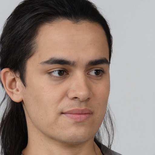 Joyful white young-adult male with long  brown hair and brown eyes