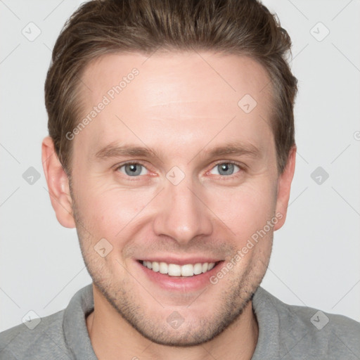 Joyful white young-adult male with short  brown hair and grey eyes