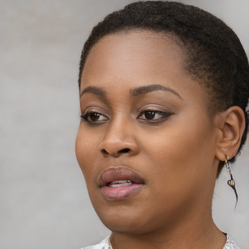 Joyful black young-adult female with short  brown hair and brown eyes