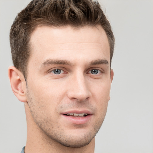 Joyful white young-adult male with short  brown hair and grey eyes