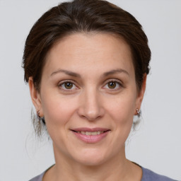 Joyful white adult female with medium  brown hair and grey eyes