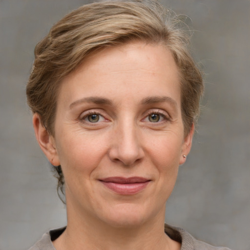 Joyful white adult female with medium  brown hair and grey eyes