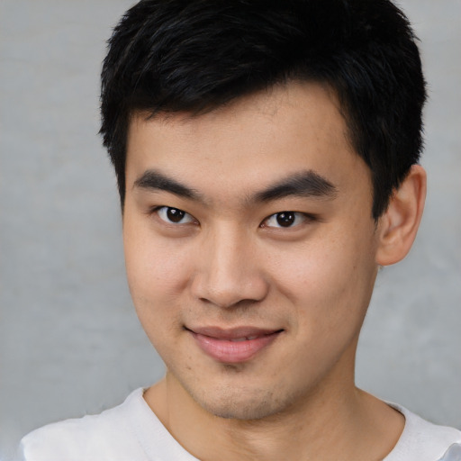 Joyful asian young-adult male with short  black hair and brown eyes