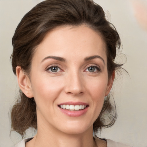 Joyful white young-adult female with medium  brown hair and green eyes