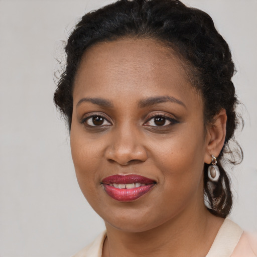 Joyful black young-adult female with long  brown hair and brown eyes