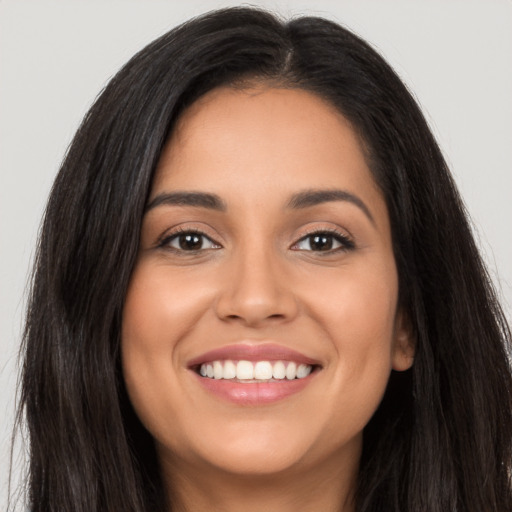 Joyful latino young-adult female with long  brown hair and brown eyes