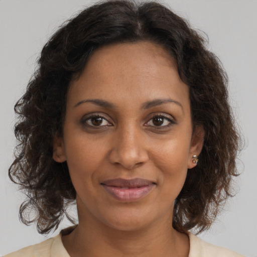 Joyful black young-adult female with medium  brown hair and brown eyes