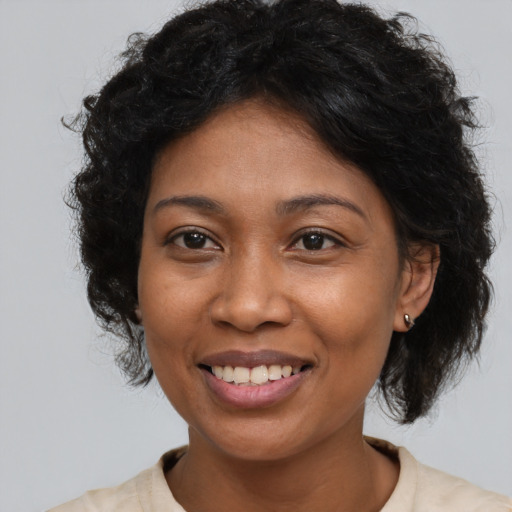Joyful black young-adult female with medium  brown hair and brown eyes