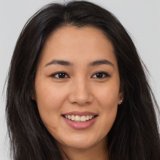 Joyful asian young-adult female with long  brown hair and brown eyes