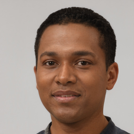 Joyful black young-adult male with short  black hair and brown eyes