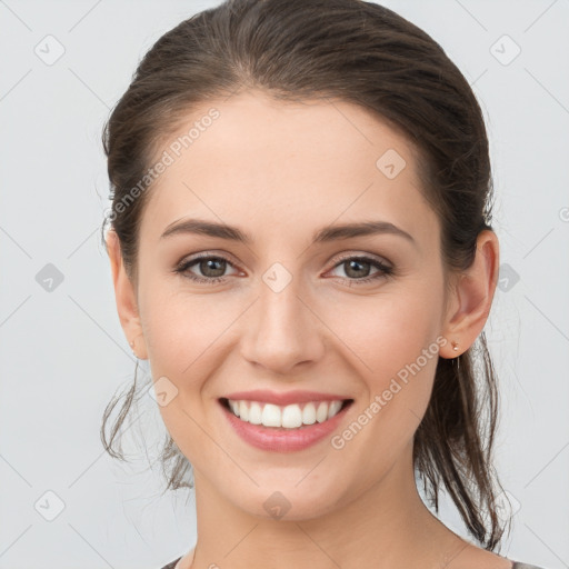 Joyful white young-adult female with medium  brown hair and grey eyes