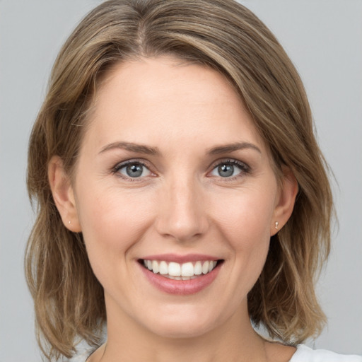 Joyful white young-adult female with medium  brown hair and grey eyes