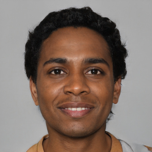 Joyful black young-adult male with short  black hair and brown eyes