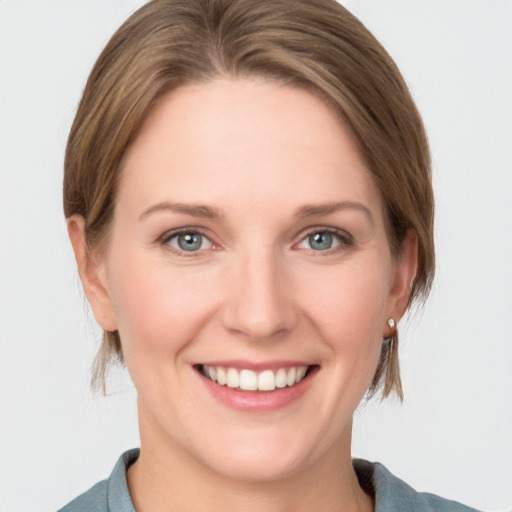 Joyful white young-adult female with medium  brown hair and grey eyes