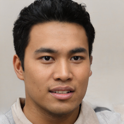 Joyful asian young-adult male with short  black hair and brown eyes