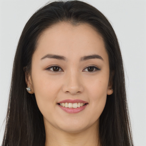 Joyful asian young-adult female with long  brown hair and brown eyes