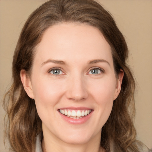 Joyful white young-adult female with long  brown hair and green eyes