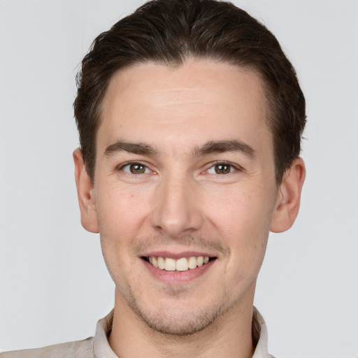 Joyful white young-adult male with short  brown hair and grey eyes