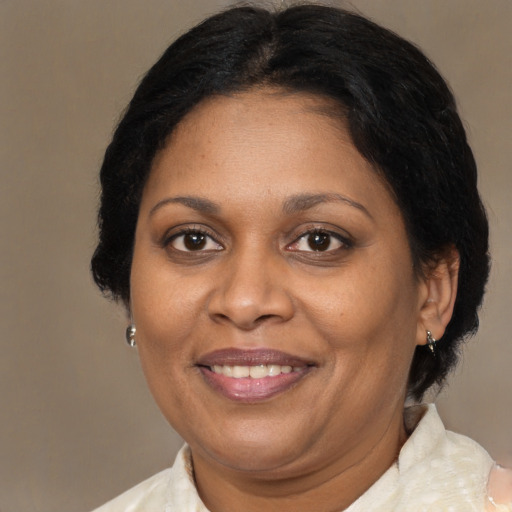 Joyful black adult female with medium  brown hair and brown eyes