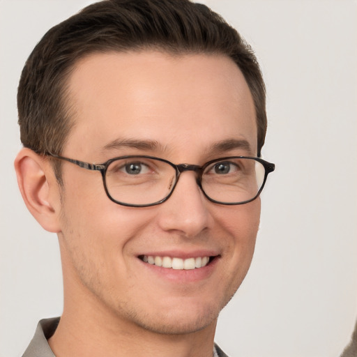 Joyful white young-adult male with short  brown hair and grey eyes