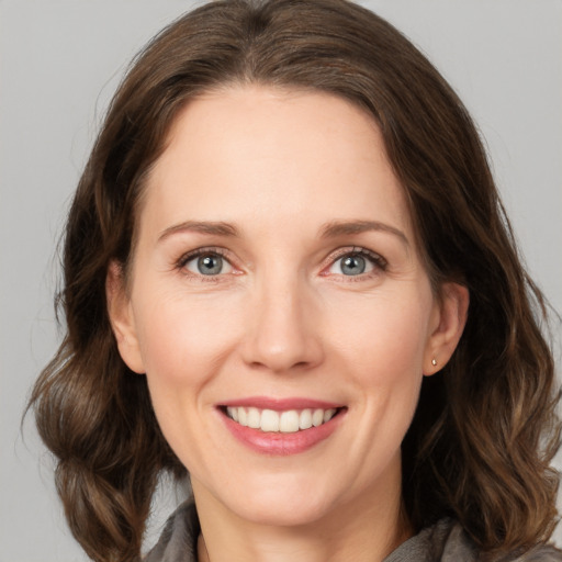 Joyful white adult female with medium  brown hair and grey eyes