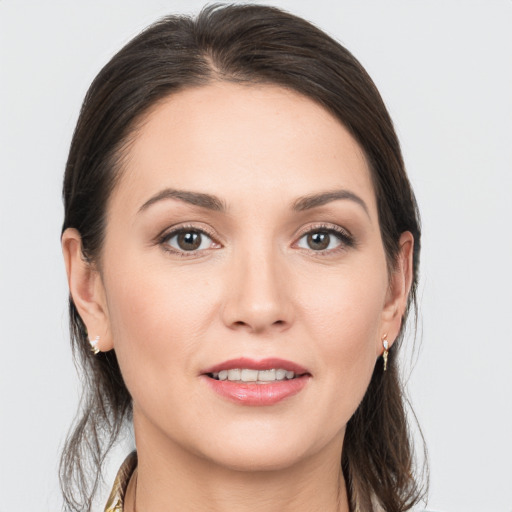 Joyful white young-adult female with medium  brown hair and grey eyes