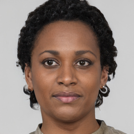 Joyful black young-adult female with short  brown hair and brown eyes