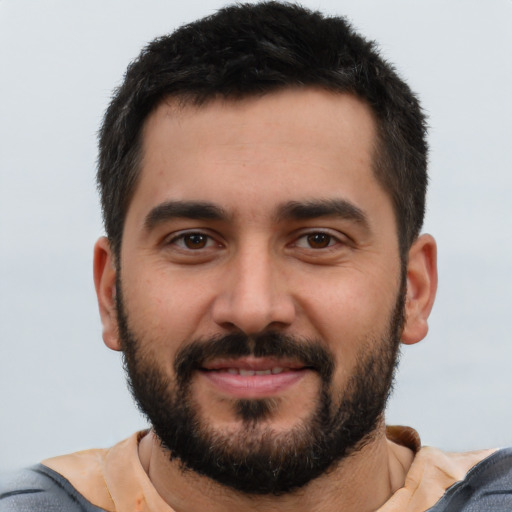 Joyful latino young-adult male with short  black hair and brown eyes