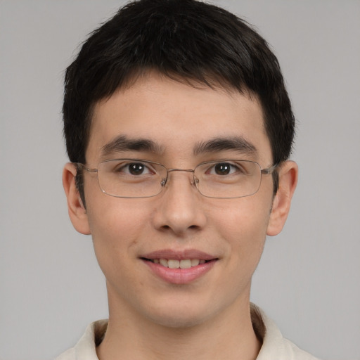 Joyful asian young-adult male with short  brown hair and brown eyes