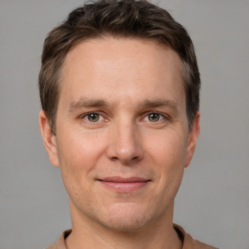 Joyful white adult male with short  brown hair and grey eyes