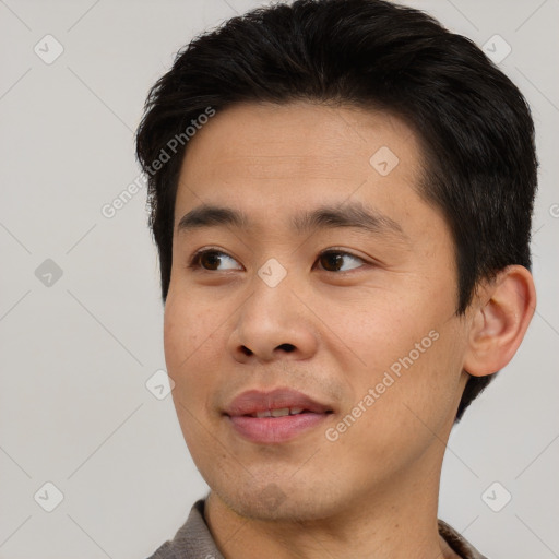 Joyful asian young-adult male with short  black hair and brown eyes