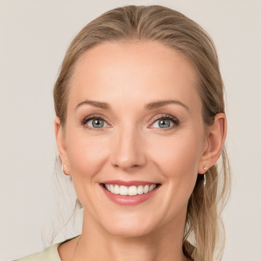 Joyful white young-adult female with medium  brown hair and blue eyes