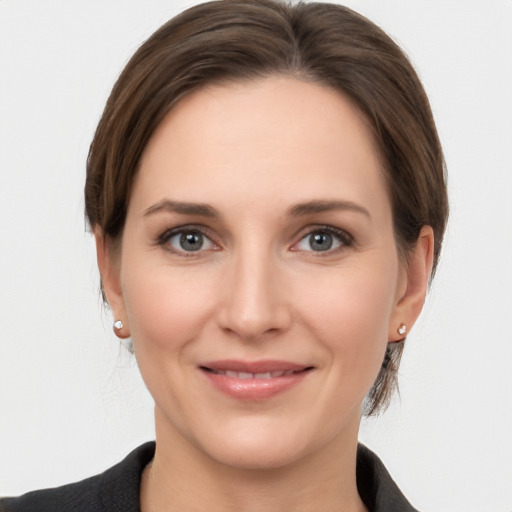 Joyful white young-adult female with medium  brown hair and grey eyes