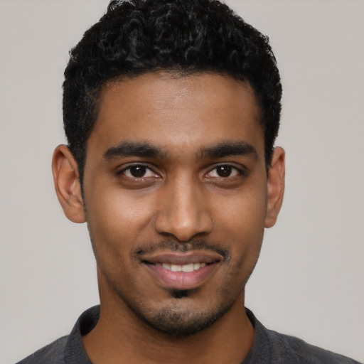 Joyful black young-adult male with short  black hair and brown eyes