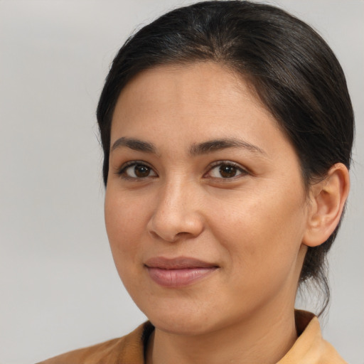 Joyful latino young-adult female with medium  brown hair and brown eyes