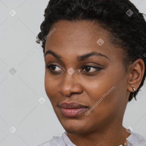 Joyful black young-adult female with short  black hair and brown eyes