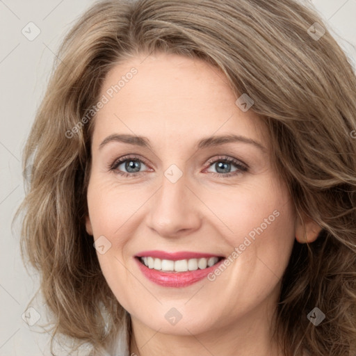 Joyful white young-adult female with long  brown hair and green eyes