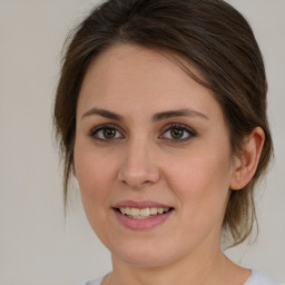 Joyful white young-adult female with medium  brown hair and green eyes