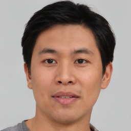 Joyful asian young-adult male with short  brown hair and brown eyes