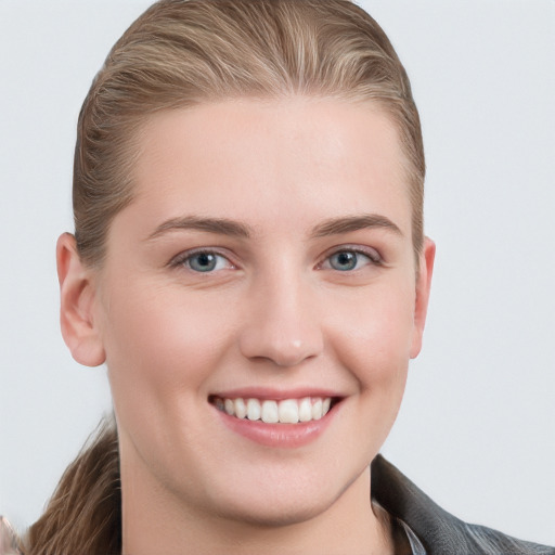 Joyful white young-adult female with long  brown hair and blue eyes