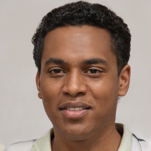Joyful black young-adult male with short  black hair and brown eyes