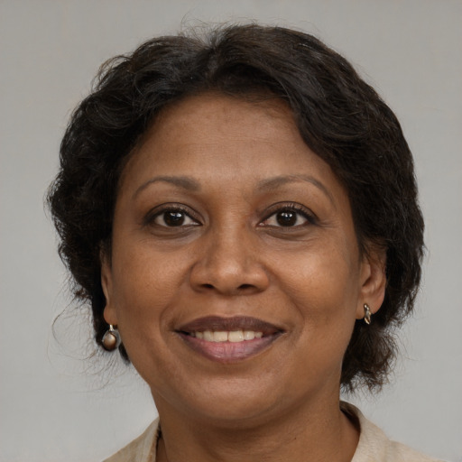 Joyful black adult female with medium  brown hair and brown eyes